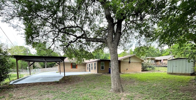 back of house with fence, an outdoor structure, a patio, a storage unit, and brick siding