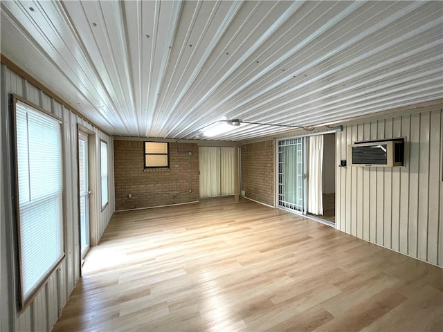 spare room featuring light wood-style floors and brick wall