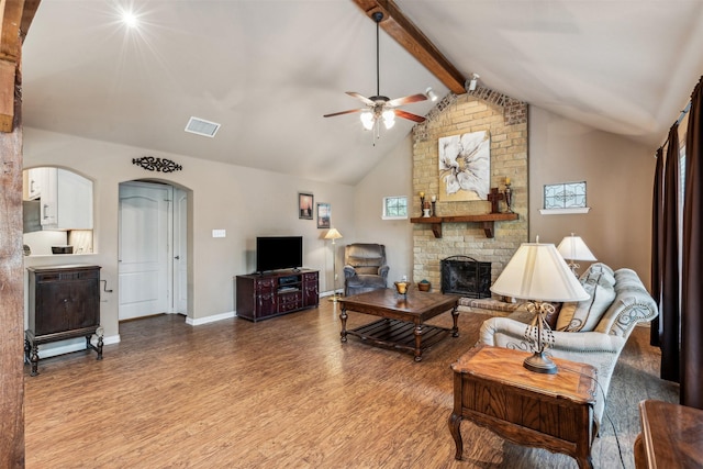 living room featuring wood finished floors, lofted ceiling with beams, ceiling fan, arched walkways, and visible vents