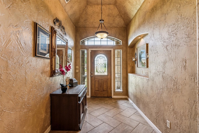 entryway featuring high vaulted ceiling and baseboards