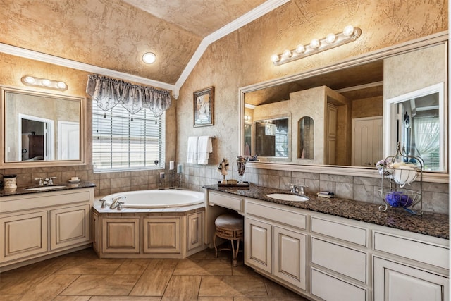 full bath with a garden tub, crown molding, a sink, lofted ceiling, and two vanities