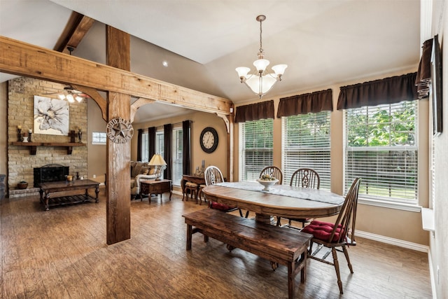 dining area with lofted ceiling with beams, light wood-type flooring, baseboards, a notable chandelier, and a fireplace