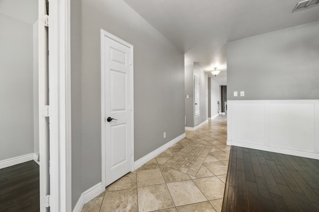 corridor with baseboards and visible vents