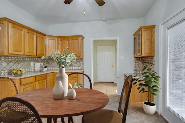 6424 County Road 176, Stephenville, TX 76401 - kitchen featuring tasteful backsplash, glass insert cabinets, a ceiling fan, light countertops, and light tile patterned floors