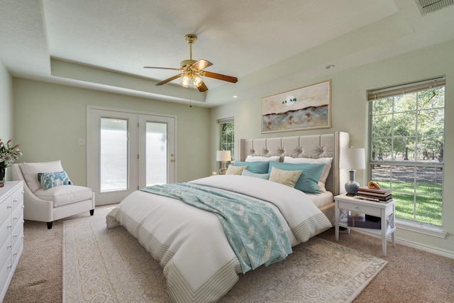 6424 County Road 176, Stephenville, TX 76401 - bedroom featuring a ceiling fan, light carpet, a tray ceiling, access to outside, and visible vents