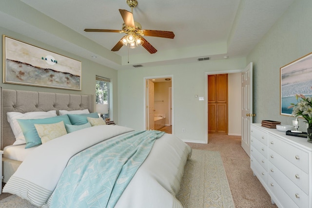 6424 County Road 176, Stephenville, TX 76401 - bedroom featuring ceiling fan, light carpet, a tray ceiling, ensuite bath, and visible vents