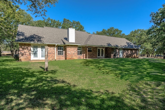 6424 County Road 176, Stephenville, TX 76401 - rear view of property featuring a chimney, central air condition unit, french doors, a lawn, and brick siding