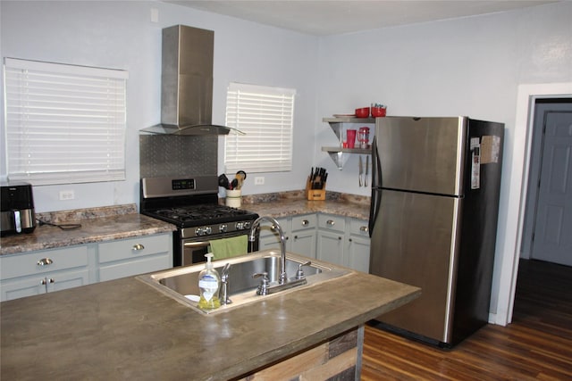 kitchen with wall chimney exhaust hood, stainless steel appliances, dark wood-type flooring, and a sink
