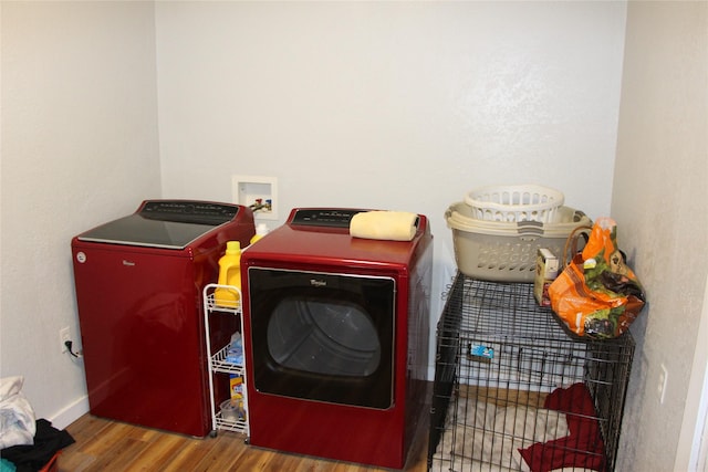 laundry room featuring baseboards, wood finished floors, washer and dryer, and laundry area