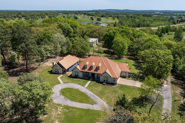 drone / aerial view with a wooded view and a water view