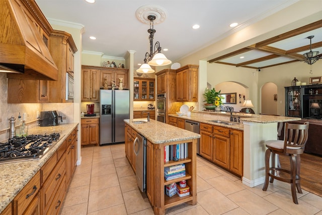 kitchen featuring custom exhaust hood, a sink, brown cabinets, and appliances with stainless steel finishes