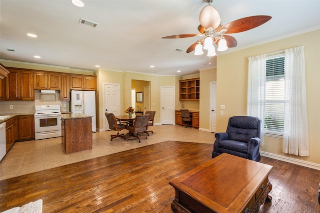 living room featuring baseboards, crown molding, visible vents, and recessed lighting