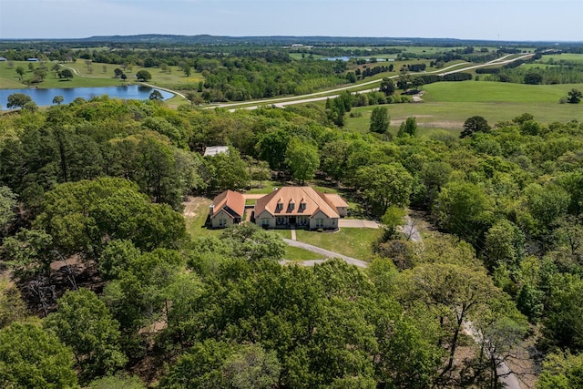 birds eye view of property featuring a view of trees and a water view