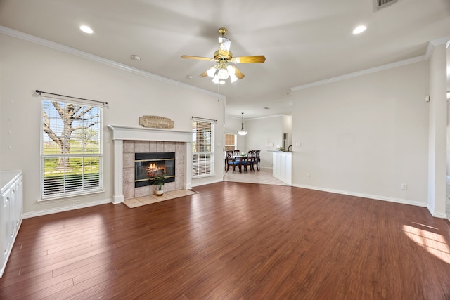 560 Glenn Ln, Red Oak, TX 75154 - unfurnished living room with wood finished floors, crown molding, ceiling fan, baseboards, and a tile fireplace
