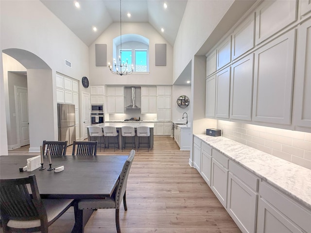 3810 Braxton Dr, Melissa, TX 75454 - dining room with high vaulted ceiling, a chandelier, light wood-style flooring, arched walkways, and recessed lighting