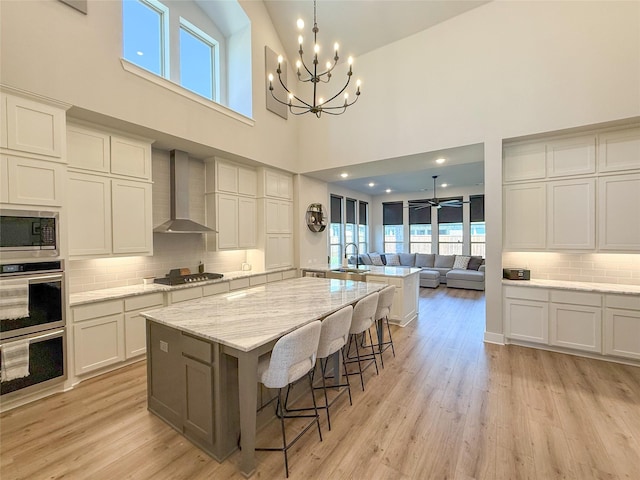 3810 Braxton Dr, Melissa, TX 75454 - kitchen with wall chimney range hood, appliances with stainless steel finishes, a sink, a chandelier, and plenty of natural light