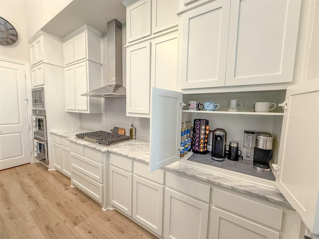 3810 Braxton Dr, Melissa, TX 75454 - kitchen with wall chimney range hood, stainless steel appliances, tasteful backsplash, light wood-type flooring, and white cabinets