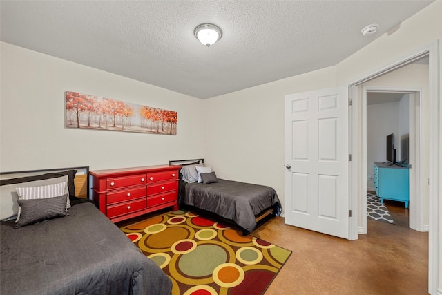 bedroom with a textured ceiling and finished concrete flooring