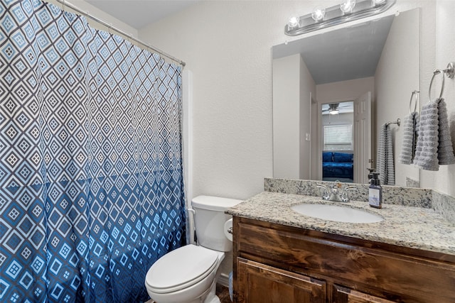 full bath featuring a textured wall, vanity, curtained shower, and toilet