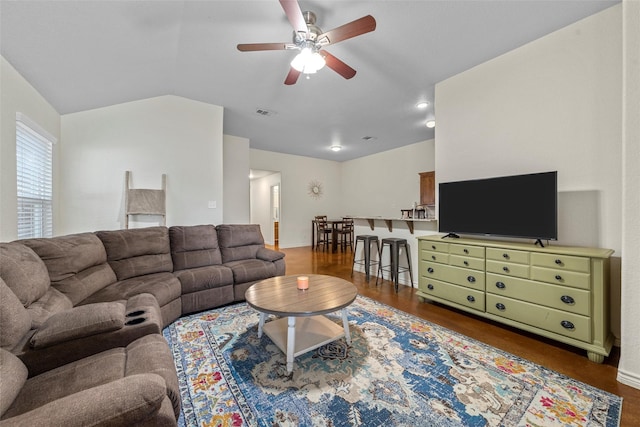 living room featuring lofted ceiling, a ceiling fan, visible vents, and baseboards