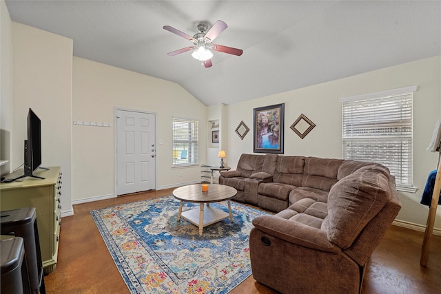 living room featuring concrete flooring, lofted ceiling, baseboards, and ceiling fan