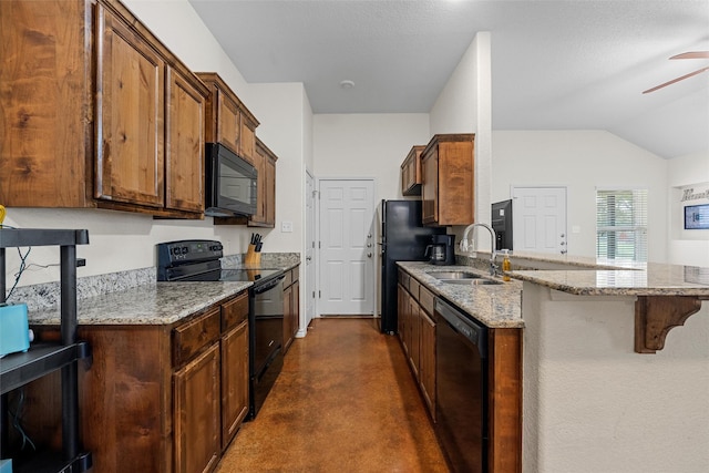kitchen with a peninsula, a sink, black appliances, concrete floors, and a breakfast bar area