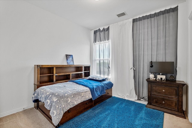 bedroom with baseboards, visible vents, and carpet