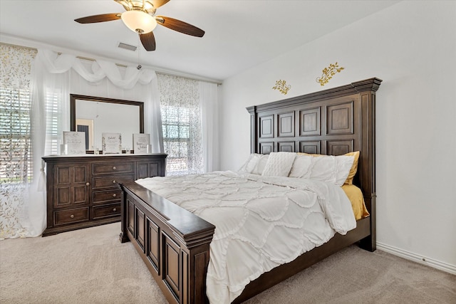 bedroom with light colored carpet, a ceiling fan, and visible vents