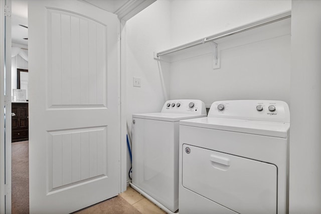 washroom featuring washer and dryer, laundry area, and light tile patterned floors