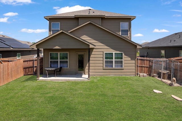 back of property with a patio area, a fenced backyard, and a yard