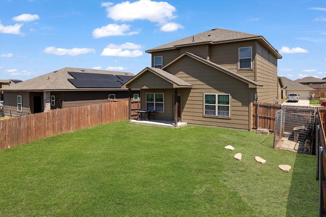 back of property with a fenced backyard, a patio, a shingled roof, and a lawn