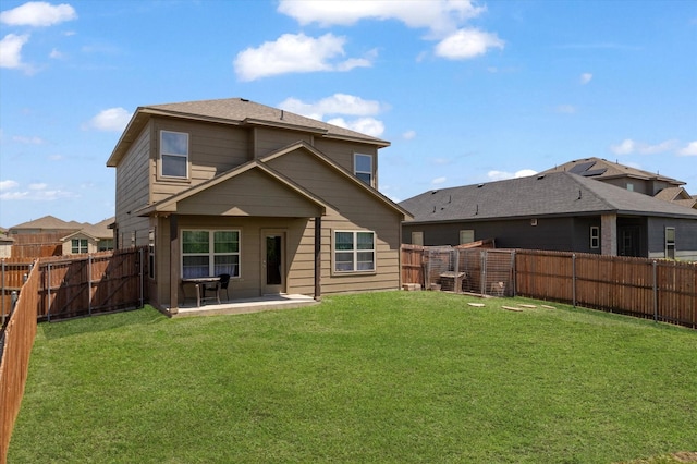 back of house featuring a lawn, a patio, and a fenced backyard