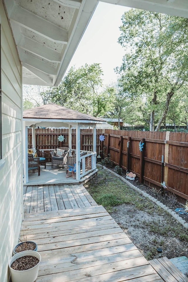 wooden deck with a fenced backyard, a gazebo, and an outdoor hangout area