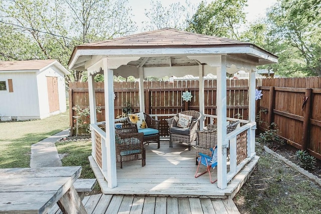 wooden terrace with a storage unit, a fenced backyard, a gazebo, outdoor lounge area, and an outdoor structure