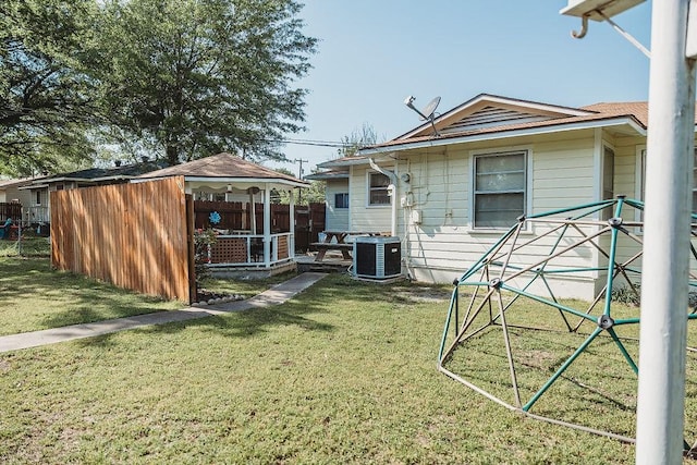back of property with fence, a yard, cooling unit, and a gazebo