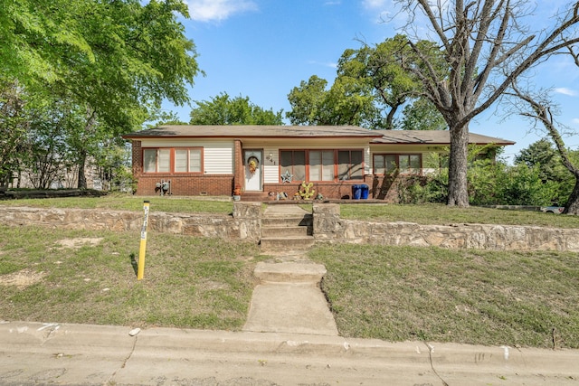 single story home with a front yard and brick siding