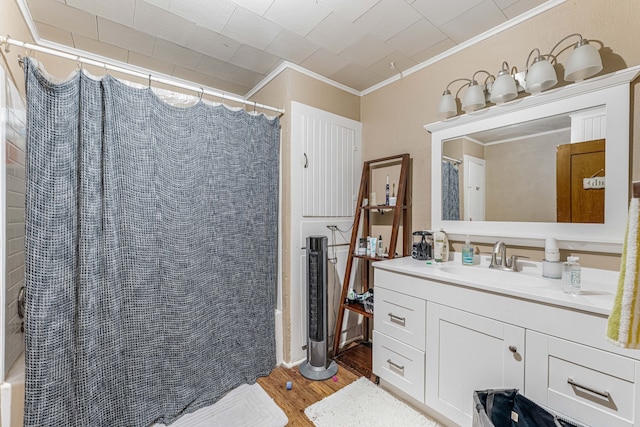 bathroom with crown molding, vanity, and wood finished floors