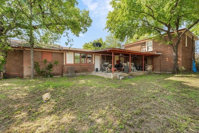 back of house featuring brick siding and a patio