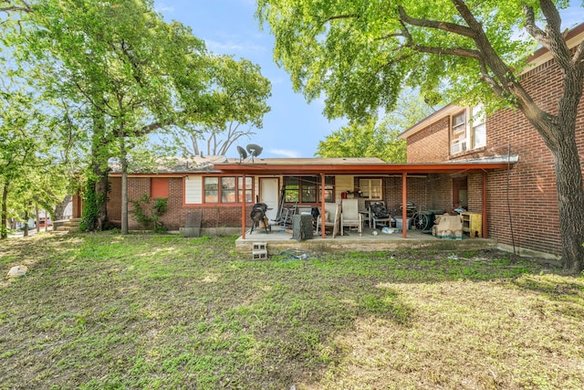 back of house with brick siding and a patio