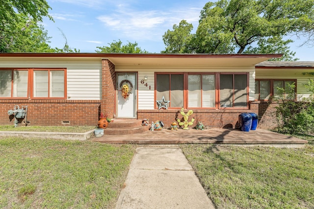 ranch-style home featuring brick siding, crawl space, and a front yard