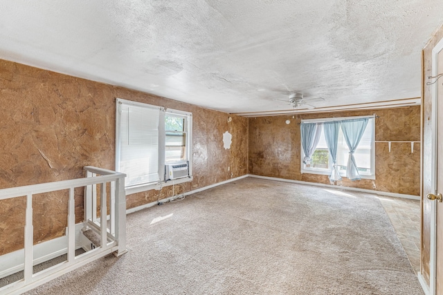 unfurnished room featuring cooling unit, plenty of natural light, a ceiling fan, and a textured ceiling