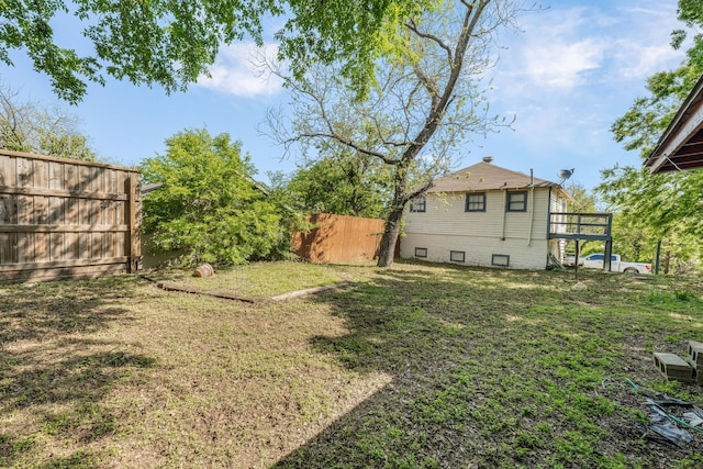 view of yard featuring fence and a deck