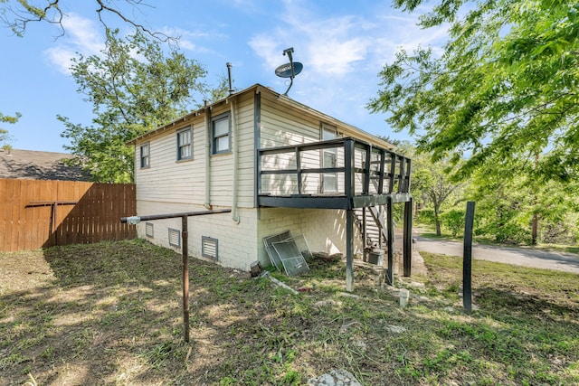 view of home's exterior with fence, stairs, and a deck