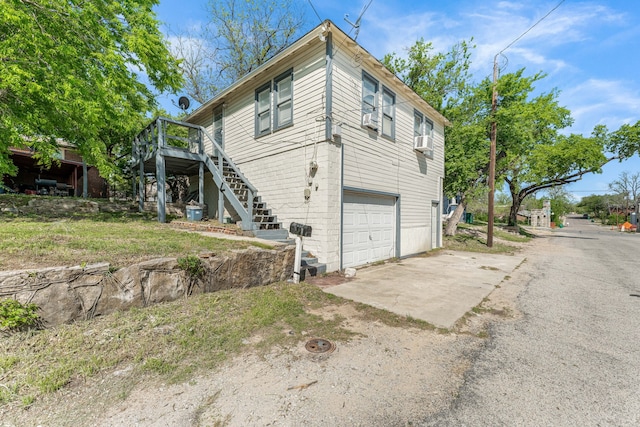 view of property exterior featuring stairs, cooling unit, a wooden deck, driveway, and a garage