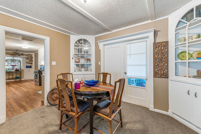 dining room featuring a textured ceiling, carpet flooring, a ceiling fan, and visible vents