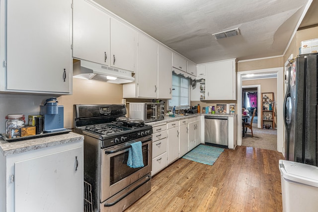 kitchen with stainless steel appliances, under cabinet range hood, light wood-style floors, and light countertops