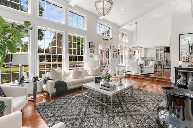 living room featuring a chandelier, wood finished floors, and high vaulted ceiling