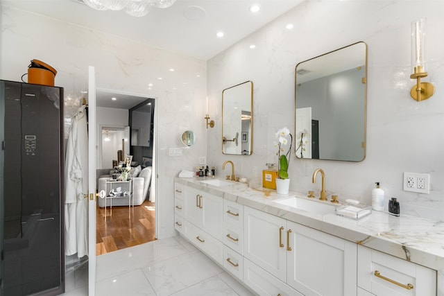 bathroom featuring marble finish floor, a sink, double vanity, and recessed lighting