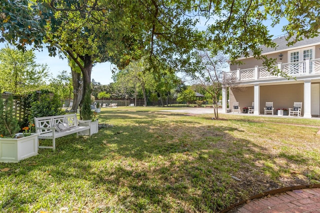 view of yard featuring a balcony and fence