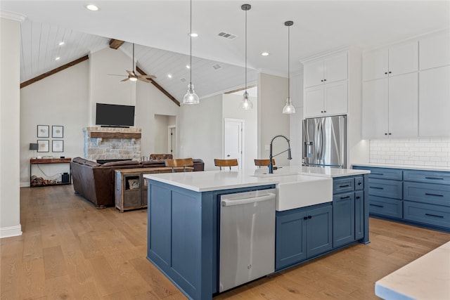 301 Wycliff Dr, Waco, TX 76633 - kitchen featuring white cabinets, stainless steel appliances, visible vents, a sink, and blue cabinetry